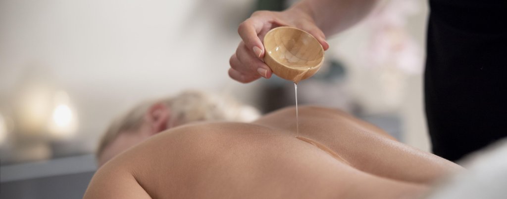 young-woman-using-massage-oil-her-client.jpg